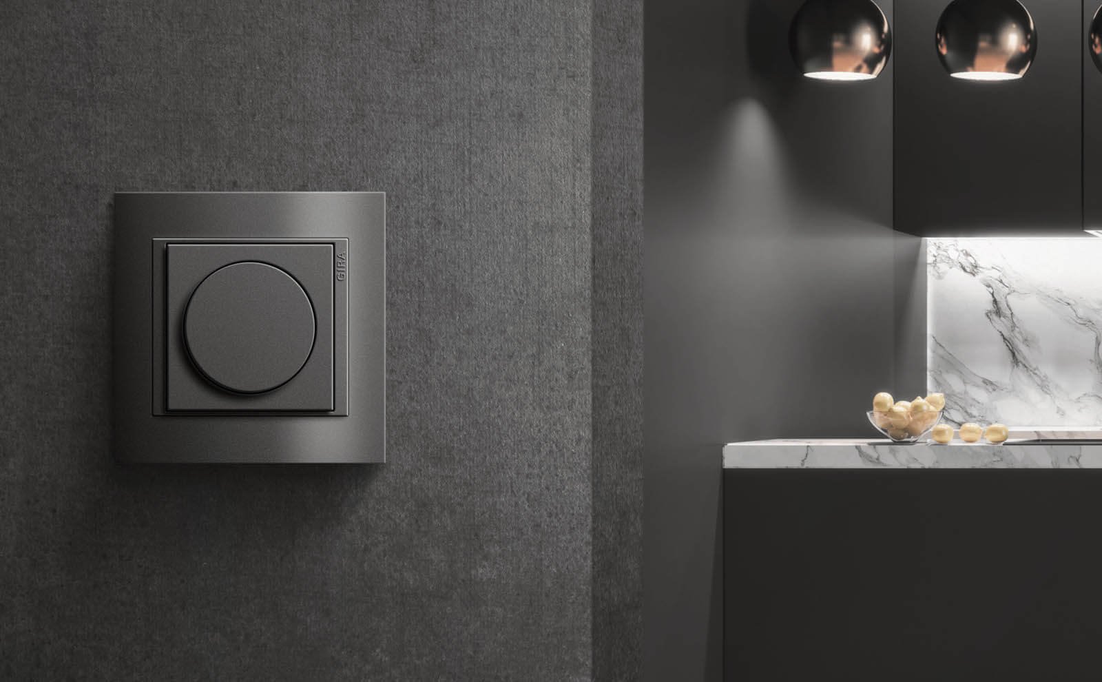 Gira Event dimmer in antraciet op een donkere wand in een keuken