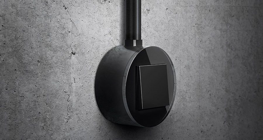 Gira Studio opbouwschakelaar glas zwart op een betonnen wand